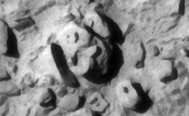 Check out the strange features or parts on the surface of the large object located in the top center next to the large rectangular block on the left. Another object with small feature or knob is located in the bottom right