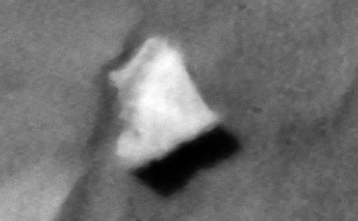 Triangular object partially buried in sand